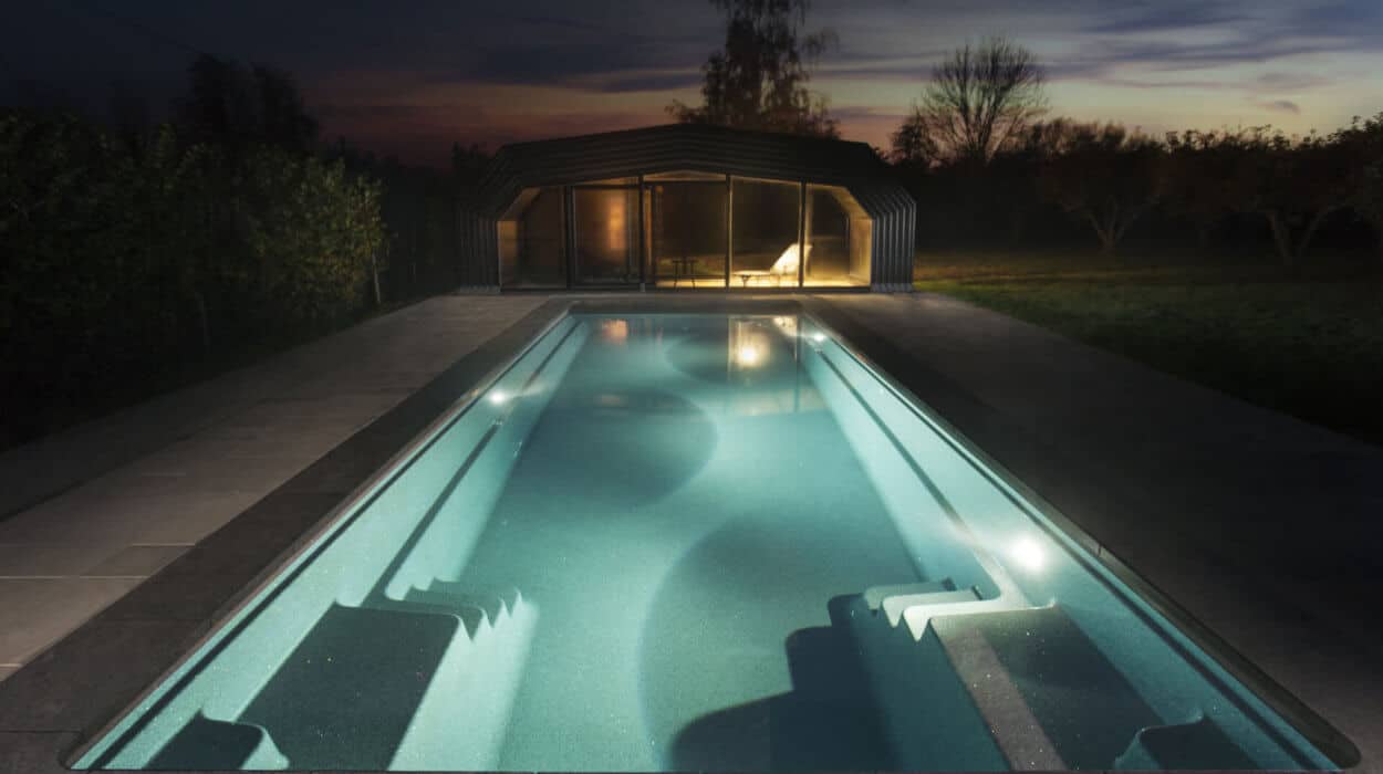 Contemporary outdoor swimming pool illuminated by soft LED lighting.