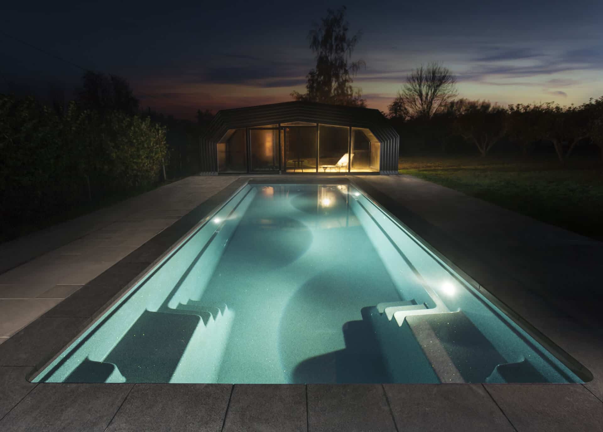 Contemporary outdoor swimming pool illuminated by soft LED lighting.