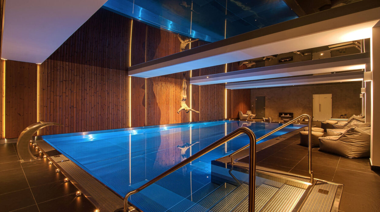 Luxury stainless steel indoor swimming pool with modern lighting.