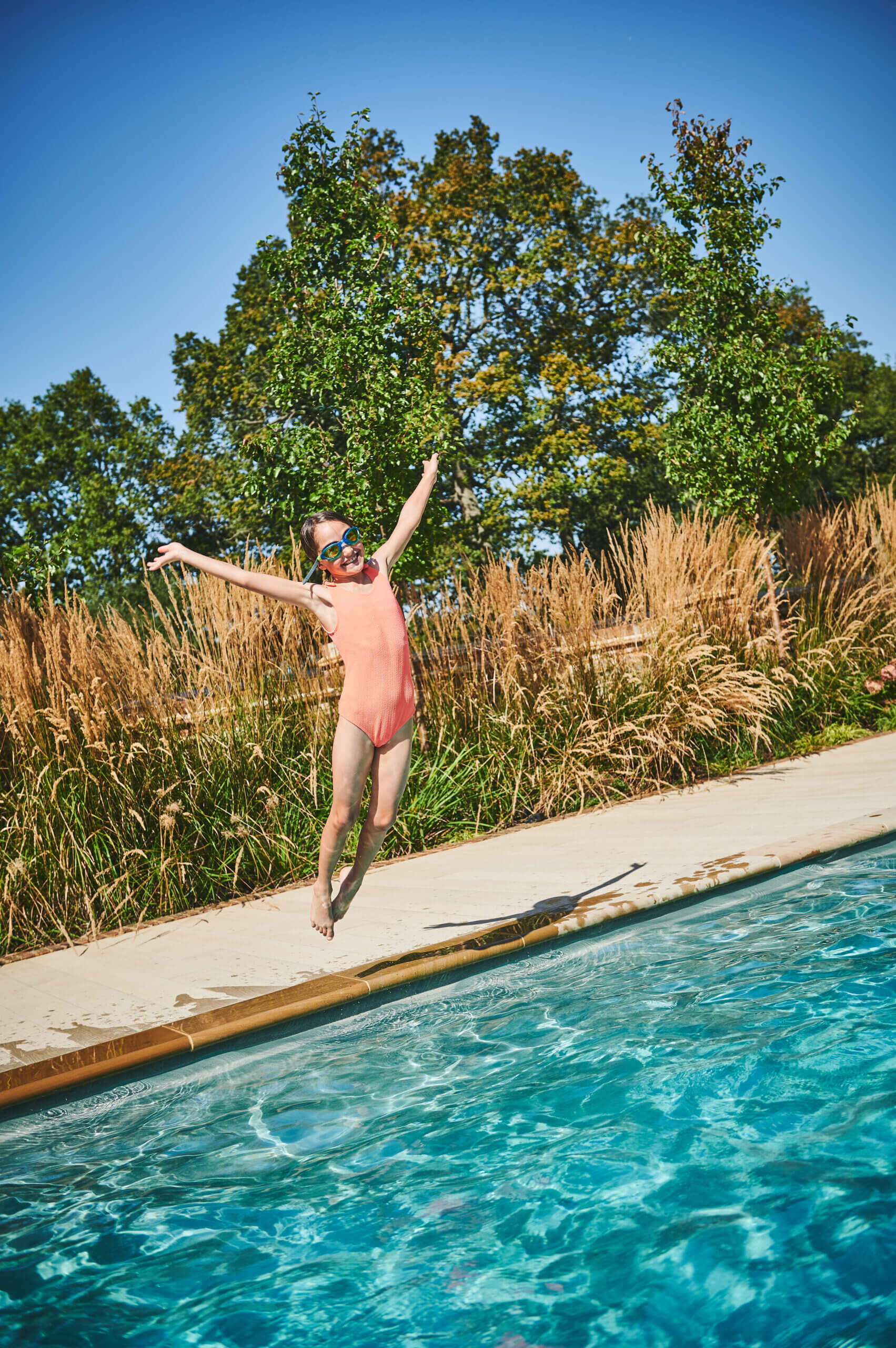 Girl jumping in to a pool